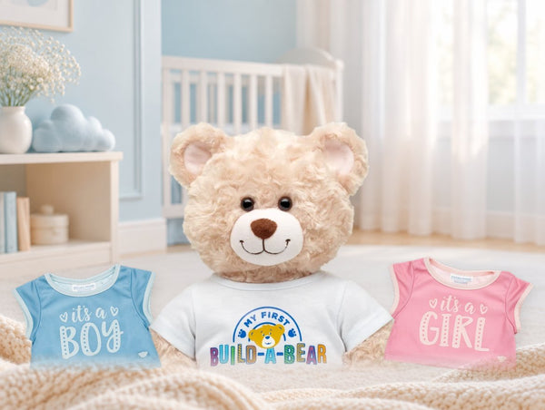 ’My First Build-A-Bear’-bamse i et lyst børneværelse med to babytøjstrøjer: ’It’s a boy’ og ’It’s a girl’